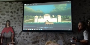 Dunakeszi, késő Római-kori erőd maradványait bemutató kiállítás. Hirschberg Attila előadás közben, a képernyőn az erőd elképzelt látványa. Fotó: Sándor Tibor